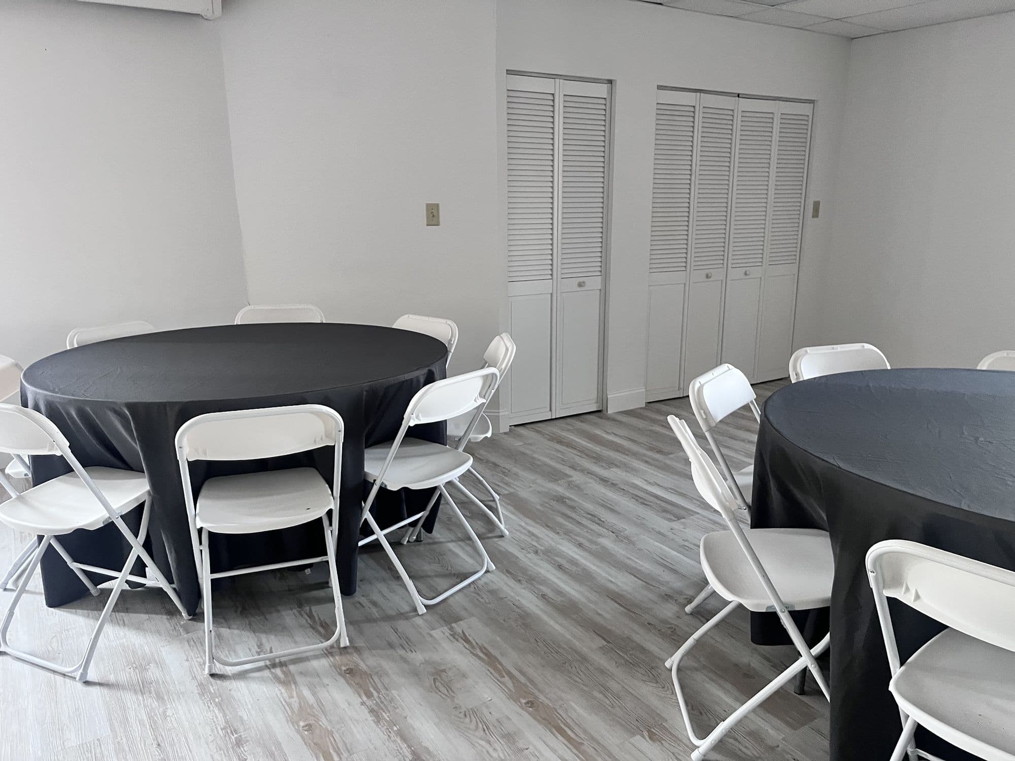 Round table banquet seating with white folding chairs in the event room