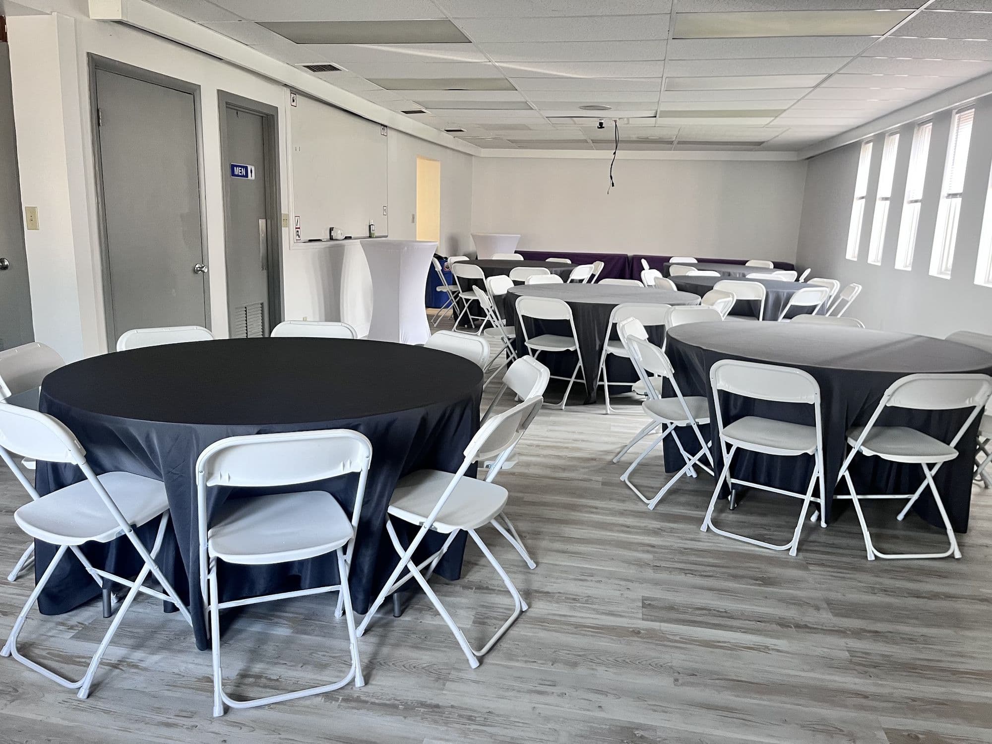 Full view of the Buffalo Event Space room with round tables set for 70+ guests