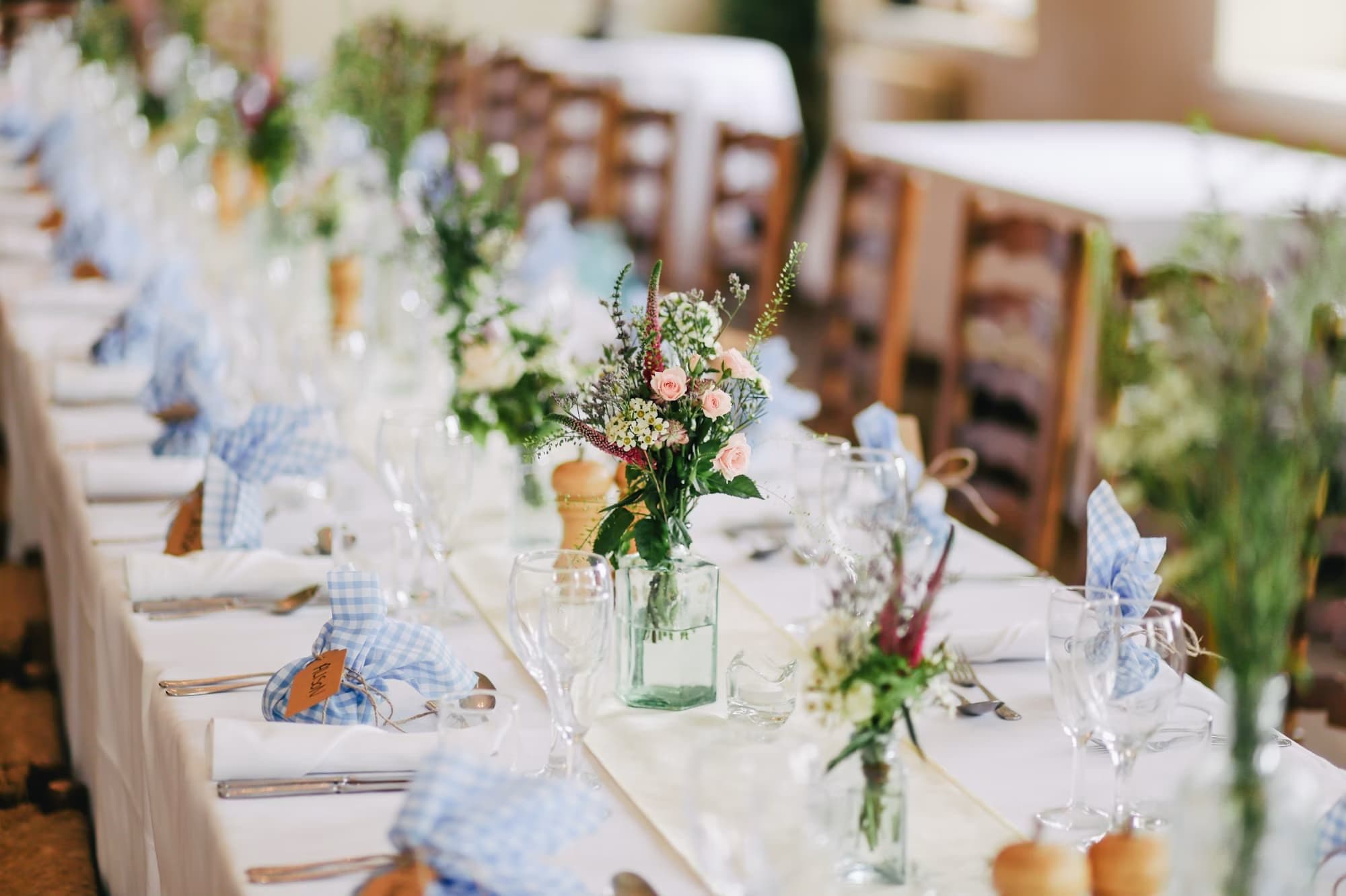 Long shower table set with florals, blue napkins and glassware